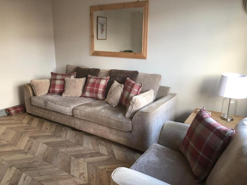 a living room with a couch and a mirror at Rowan Place 5 Bedroom Off Street Parking Accommodation in Durham