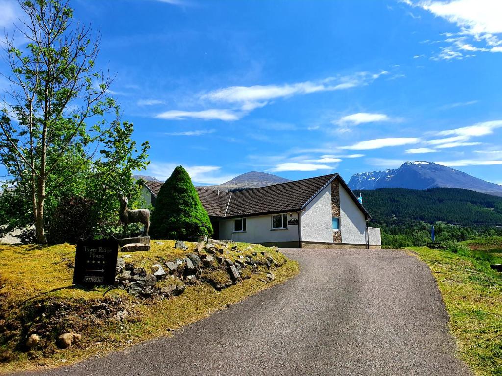 a house with a sign on the side of a road at Tower Ridge House in Fort William
