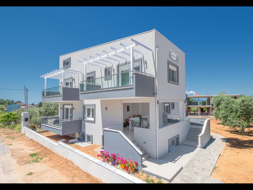 eine Einrichtung eines Hauses mit Treppen und Blumen in der Unterkunft Meliria Apartments in Skala Rachoniou