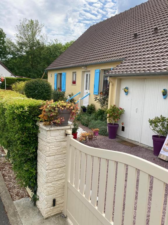 a white fence in front of a house at La Fossette in Asnelles