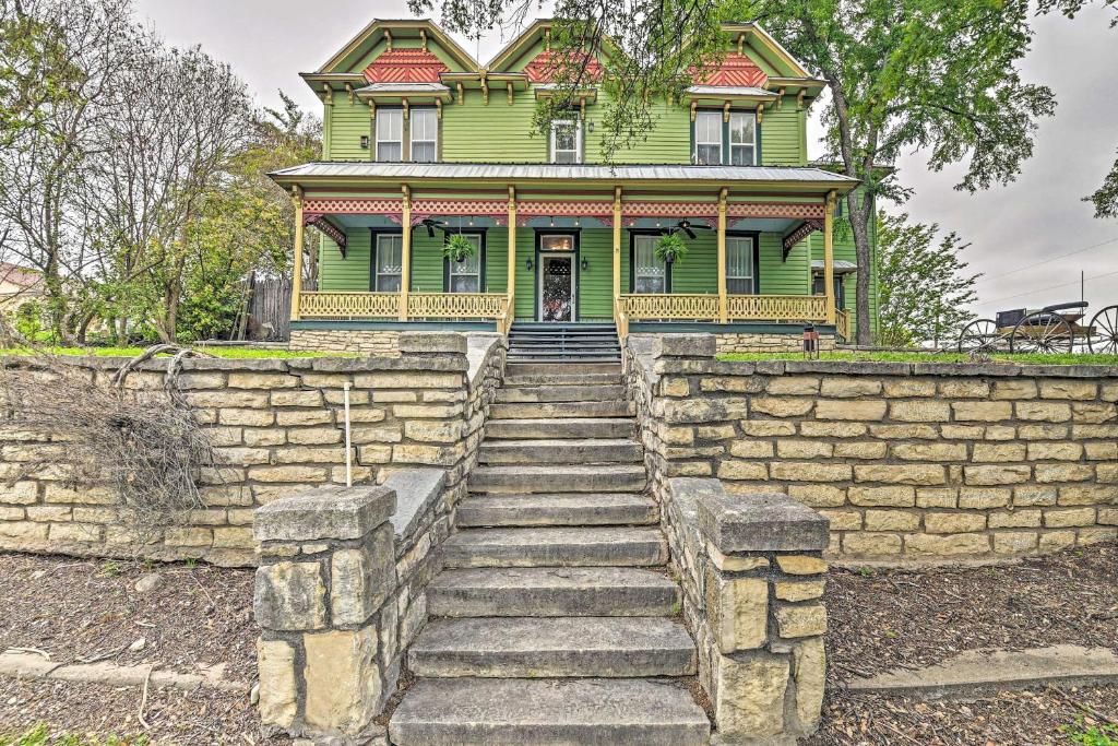 an old green house with stairs in front of it at The Lilly House Historic Glen Rose Home with Porch! in Glen Rose