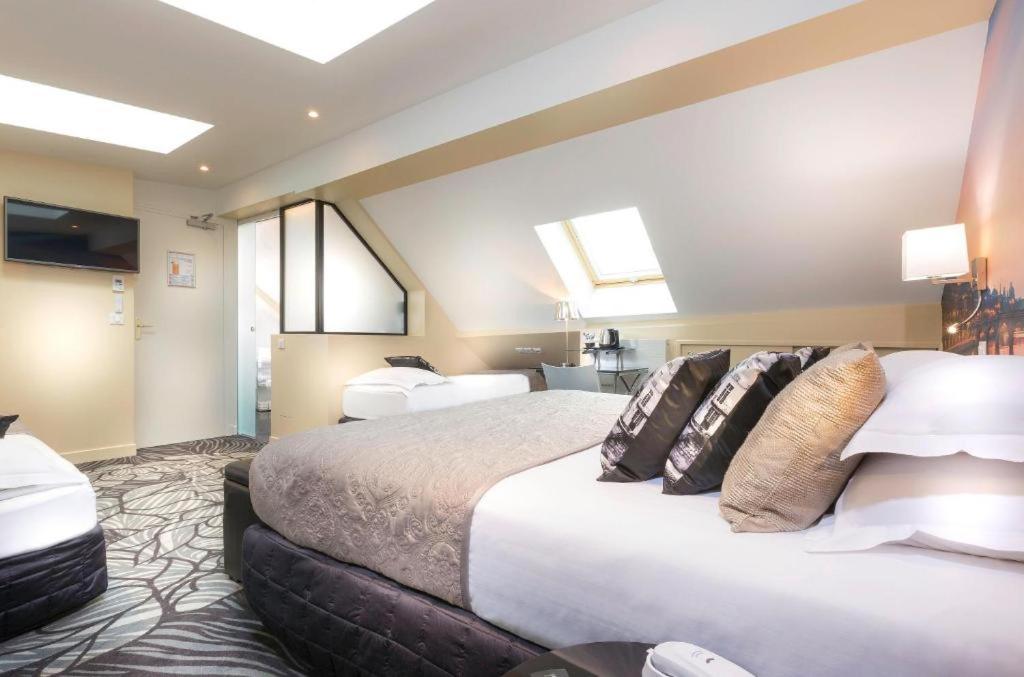 Postel nebo postele na pokoji v ubytování Hotel Ile de France Opéra
