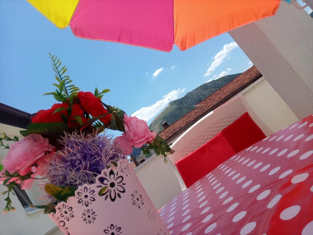 een vaas met bloemen op een tafel onder een paraplu bij Apartman Centar in Mostar