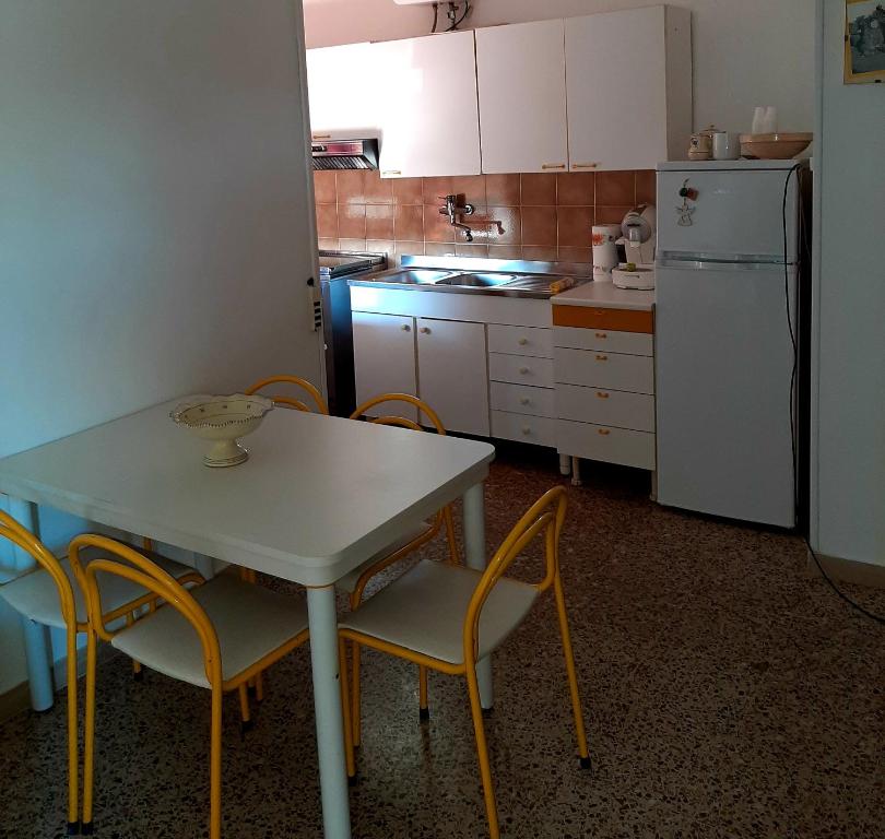 uma cozinha com uma mesa e cadeiras e um frigorífico em Casa Rosa em Crispiano