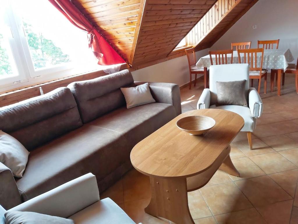 a living room with a couch and a wooden table at Hangulat Vendégház / Apartman in Harkány