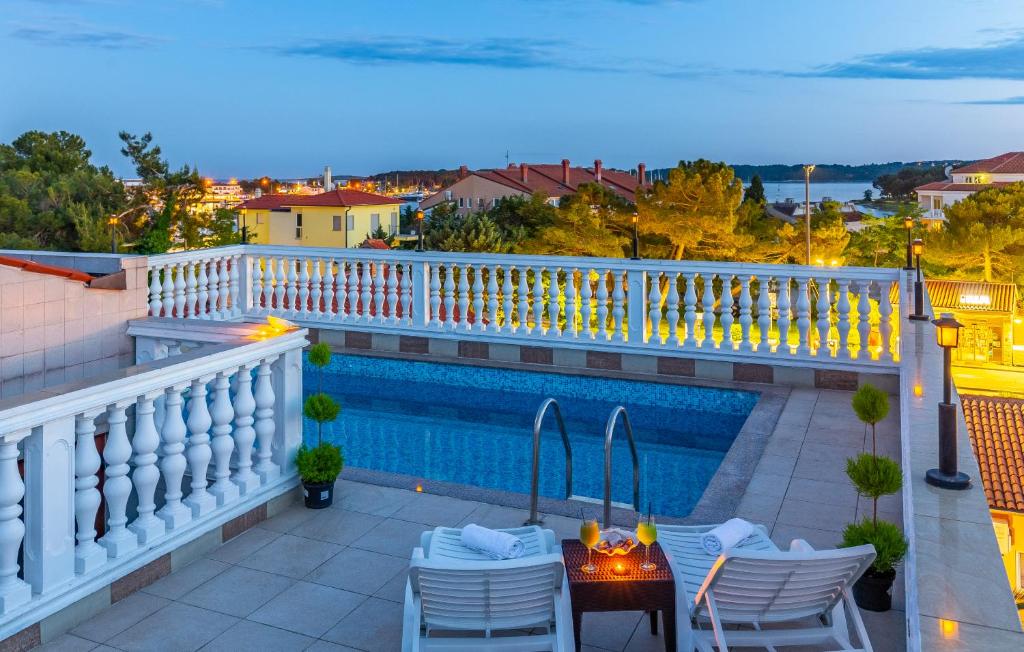 balkon ze stołem i krzesłami oraz basenem w obiekcie Villa San Rocco Bed & Breakfast w Medulinie