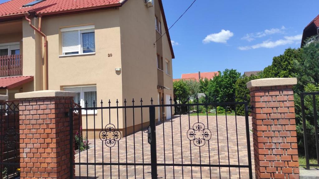 a black wrought iron fence in front of a house at Appartamenti delle vacanze in Keszthely