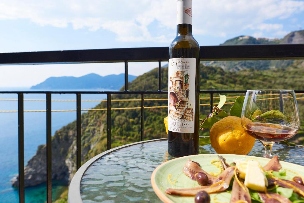 a bottle of wine and a plate of food on a table at il Magàn - Cinque Terre in Corniglia