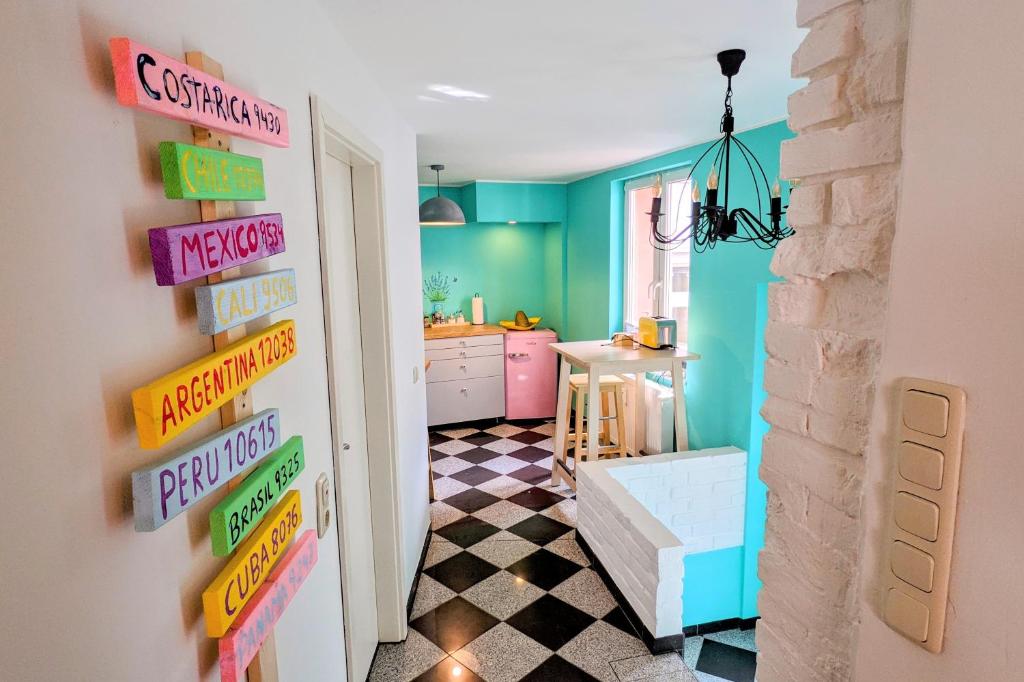 una cocina con paredes coloridas y carteles en la puerta en Casa de Pancho - Lateinamerika direkt in der City von Uelzen, en Uelzen