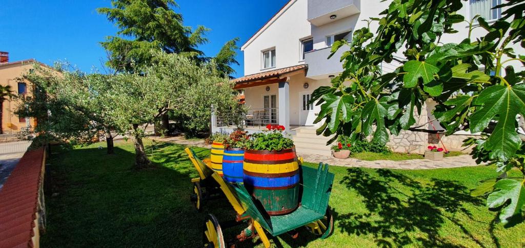 a colorful wheelbarrow with flowers on it in a yard at Nevija in Peroj