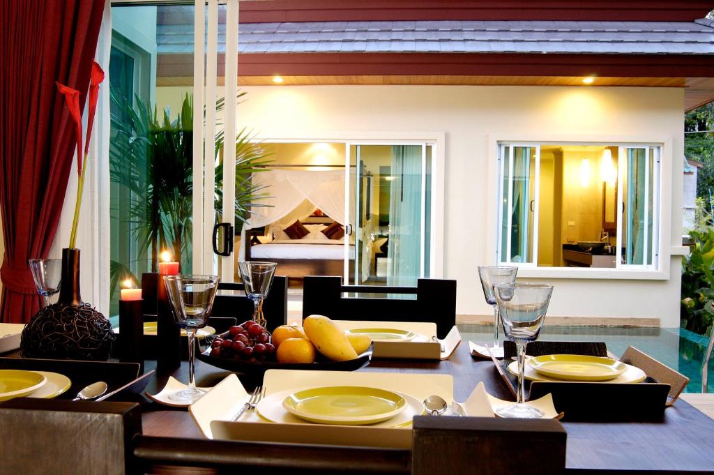 a dining room with a table with food on it at Karon Beach Walk Villa in Karon Beach