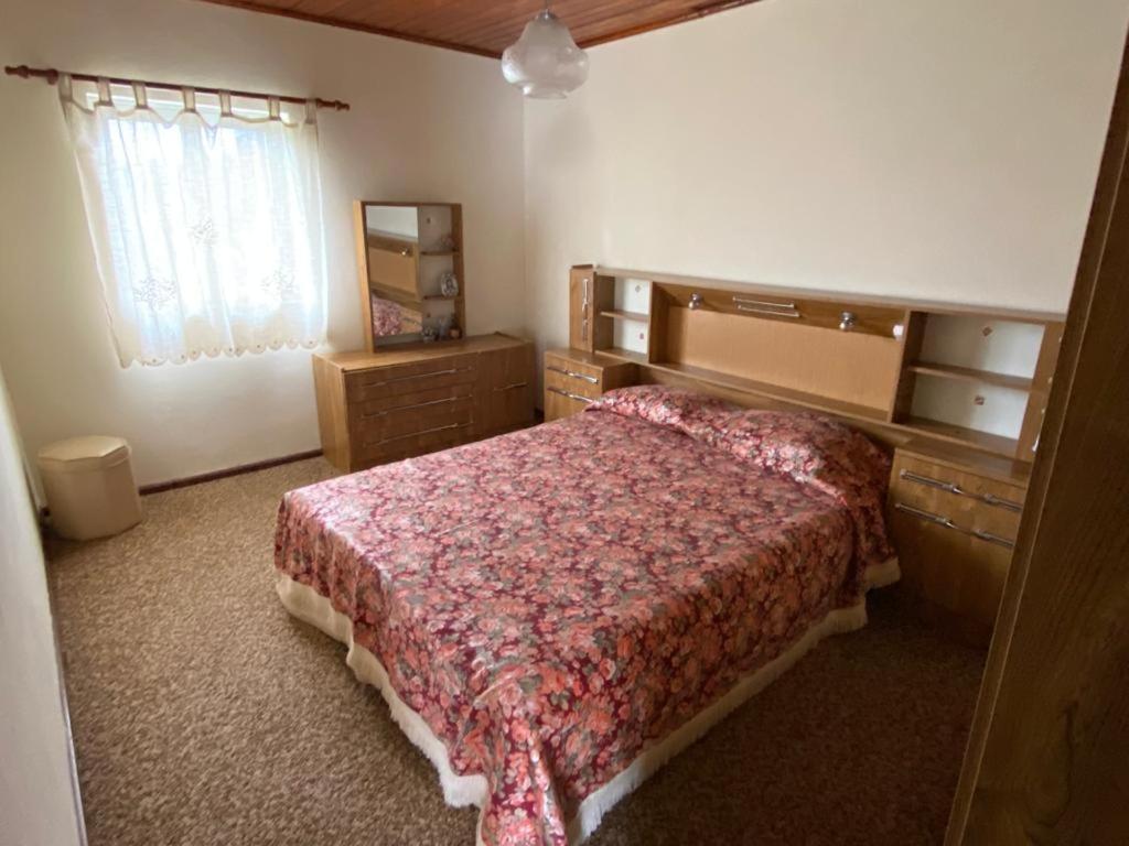 a bedroom with a large bed and a window at Alojamento da Ribeirinha in Cárquere