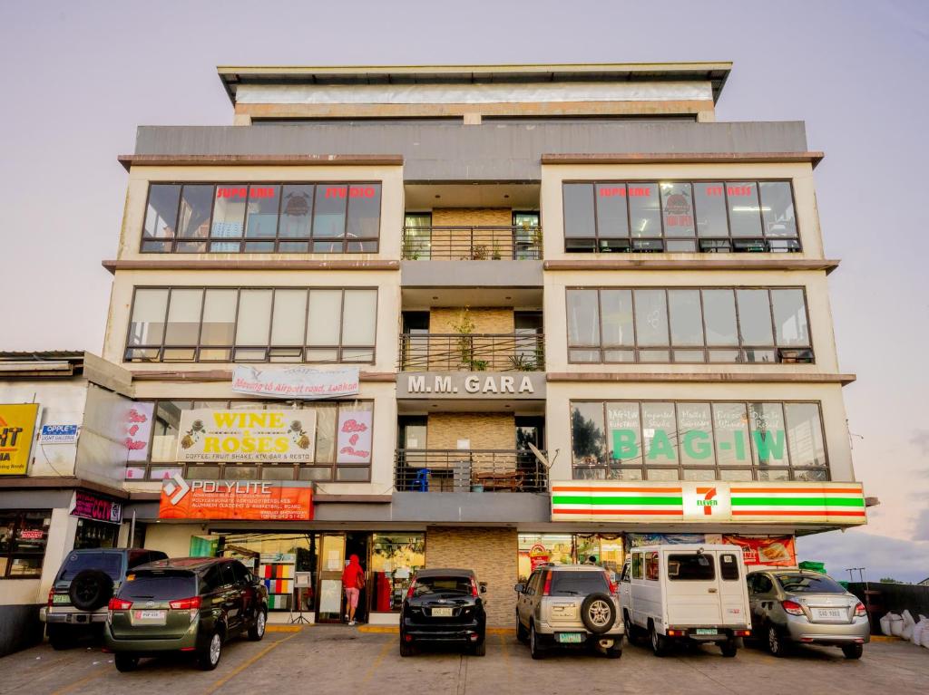 un edificio alto con coches estacionados frente a él en Casa Bel, en Baguio