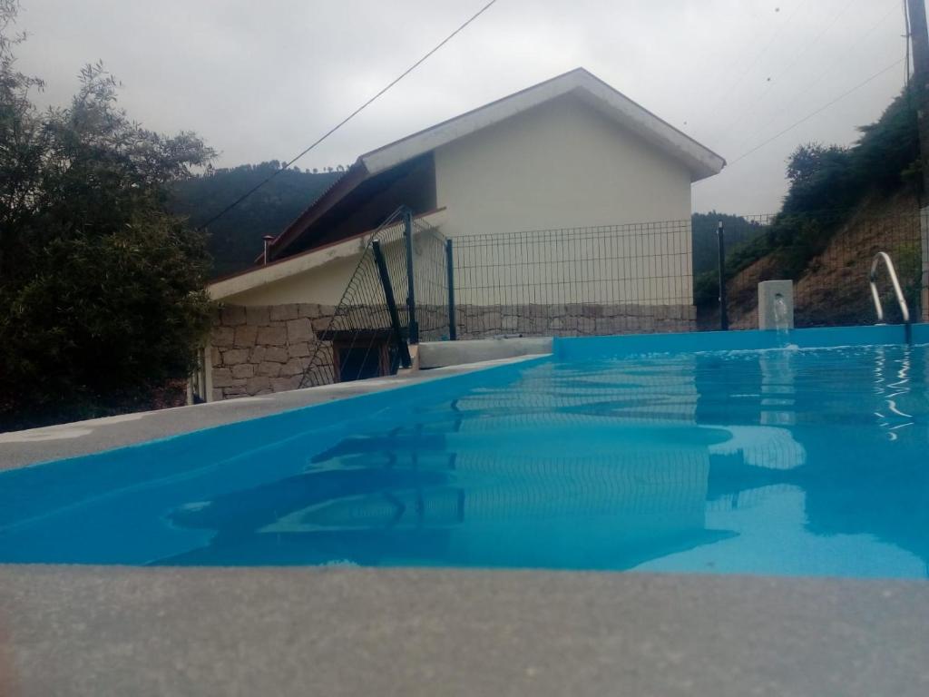 a house with a swimming pool in front of a building at A nossa Casa Gerês in Geres