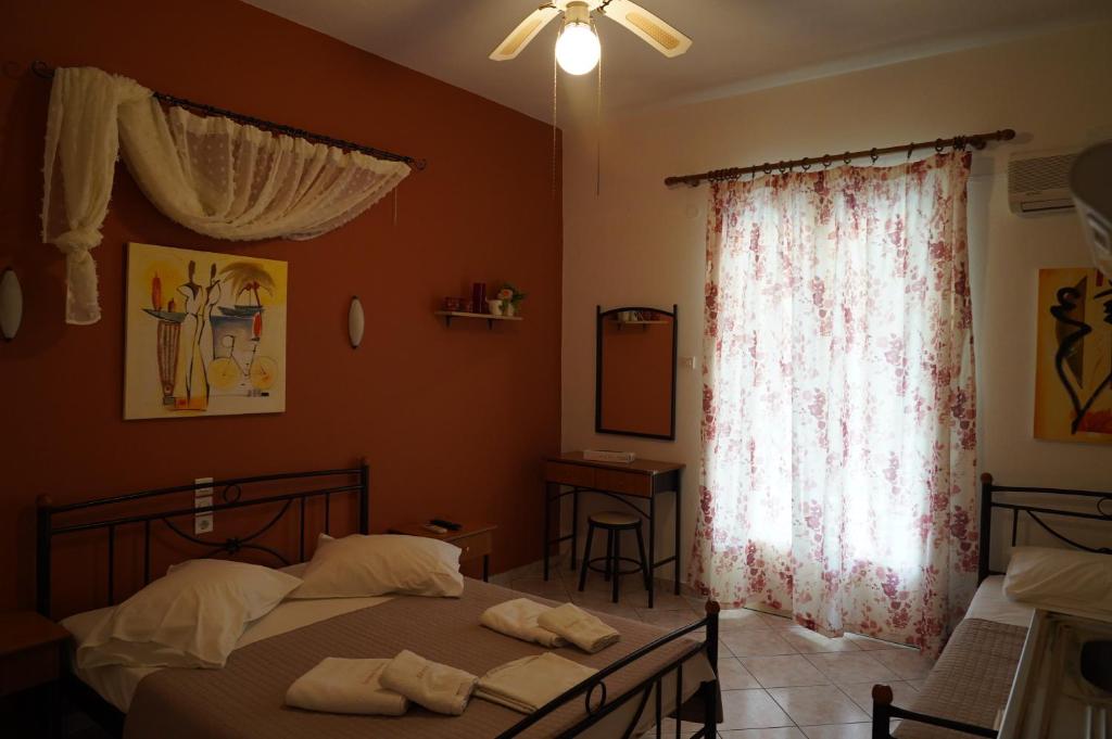 a bedroom with a bed and a window with towels on it at Drosia Studios - Λυμπερόπουλος in Pefki