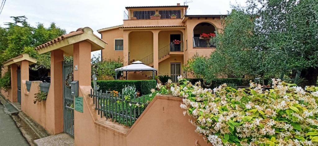 uma casa com uma cerca e flores à frente dela em B&B Casa Piras em Barumini