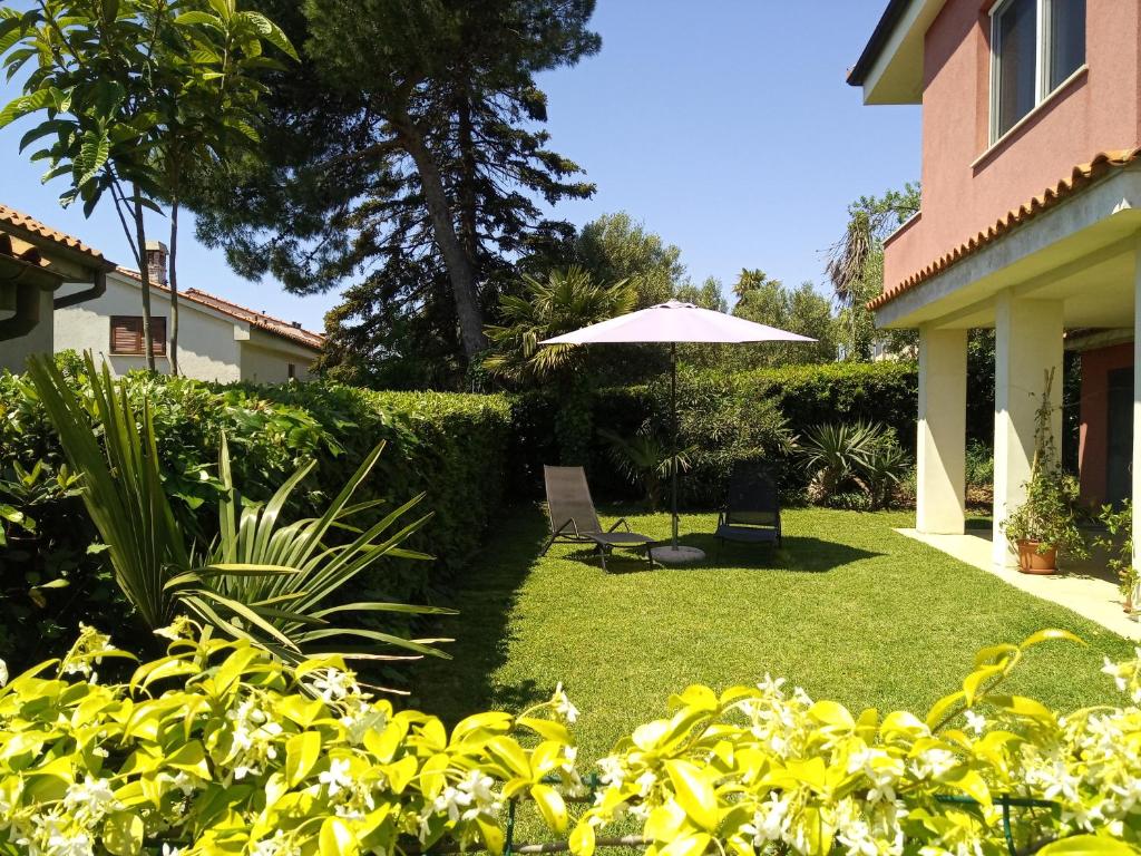a yard with a chair and an umbrella at Casa Rossa Apartment in Portorož