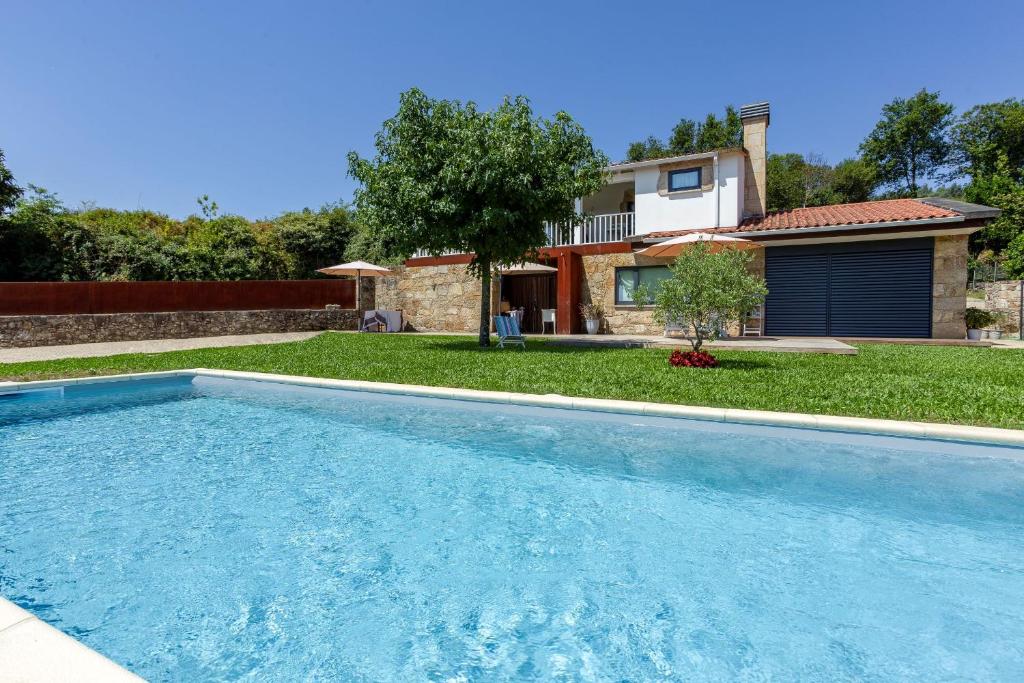 a swimming pool in front of a house at Casa Tarrio - Casa Privada com 3 Quartos e Piscina in Braga