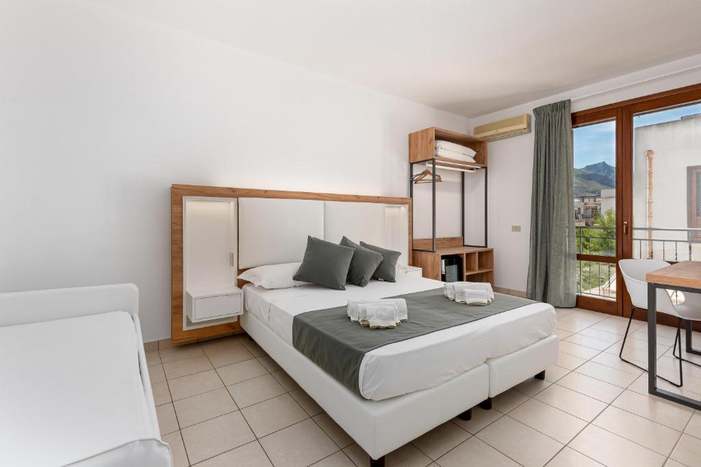 a hotel room with a bed and a dresser at Hotel Al Paradise in San Vito lo Capo