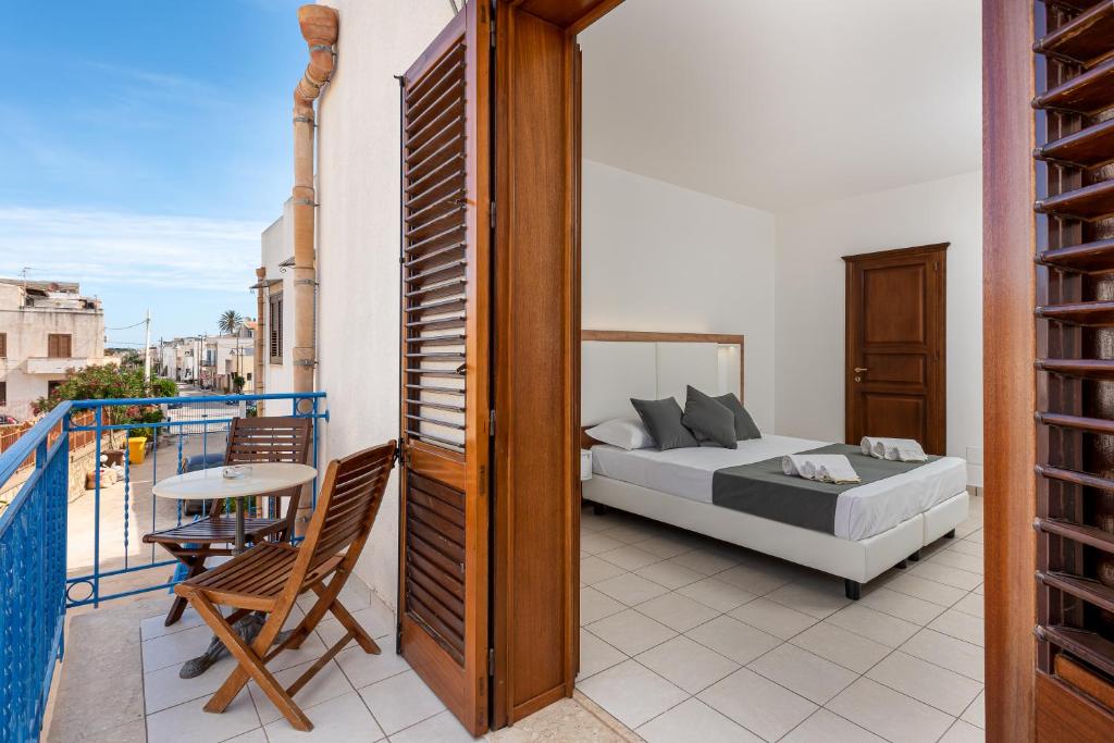 a bedroom with a bed and a table on a balcony at Hotel Al Paradise in San Vito lo Capo