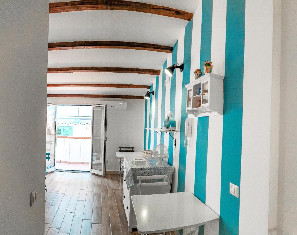 a kitchen with blue and white stripes on the walls at Dafni e Naide in Cefalù