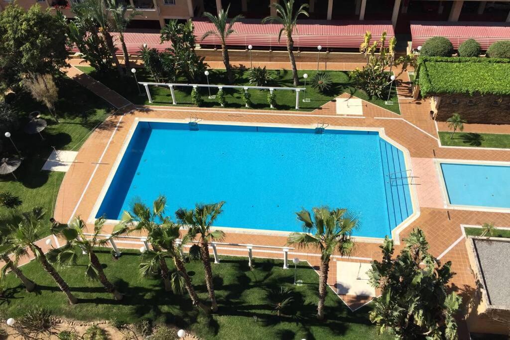 an overhead view of a large blue swimming pool at Beautiful apartment with swimming pool and beach in Alicante