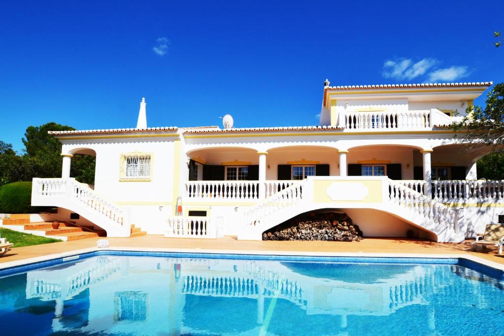 uma casa grande com uma piscina em frente em Villa Ligia by ALgest em Portimão
