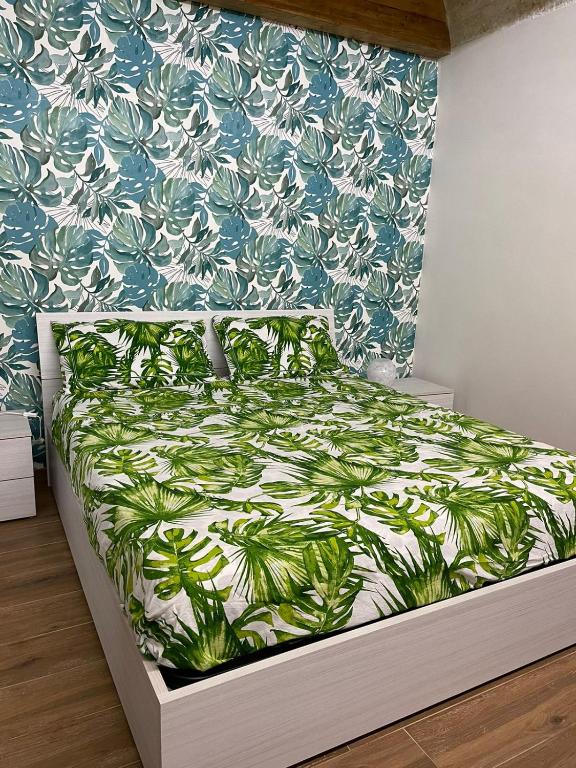 a bedroom with a bed with a green and white bedspread at Tropical House in Mola di Bari