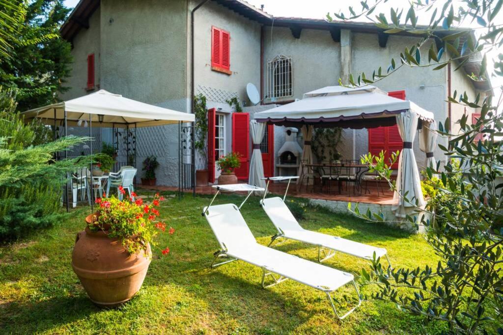 un cortile con sedie e ombrelloni e una casa di Tuscan countryside at the spa a Lari