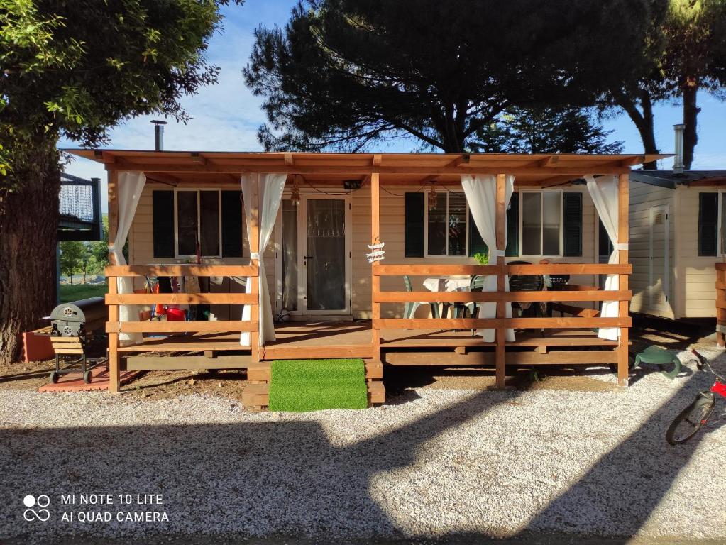 a tiny house in a yard with a fence at Casetta nel verde in Ameglia