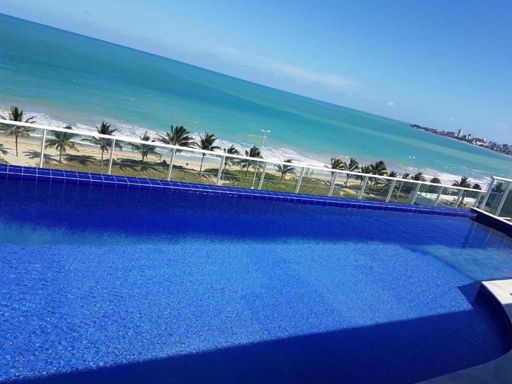 a swimming pool with a view of the beach at Flat 102 com vista parcial do Mar! in Cabedelo