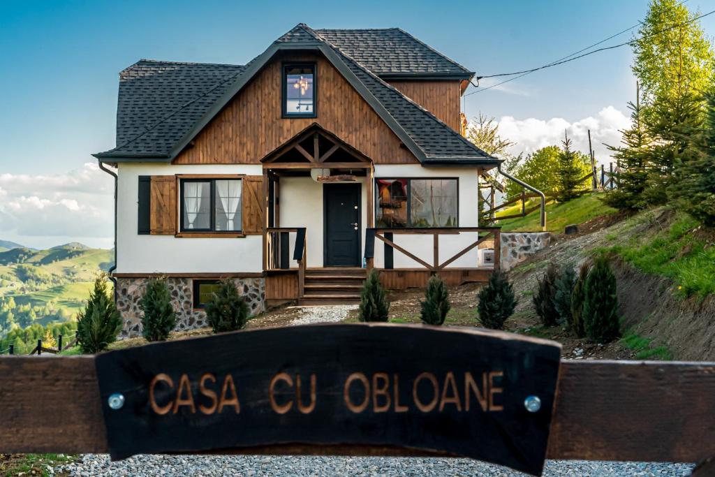 a house with a sign in front of it at Casa cu obloane, sat Pestera, Moieciu in Moieciu de Jos