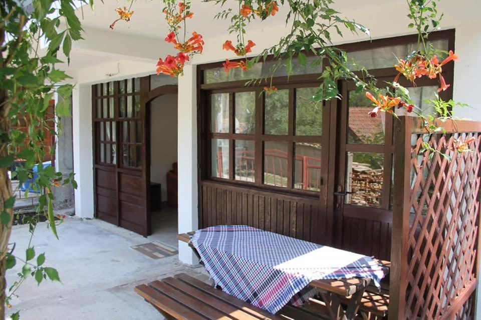un porche con una puerta de madera y una mesa en Apartman NeSa Boracko jezero, en Konjic