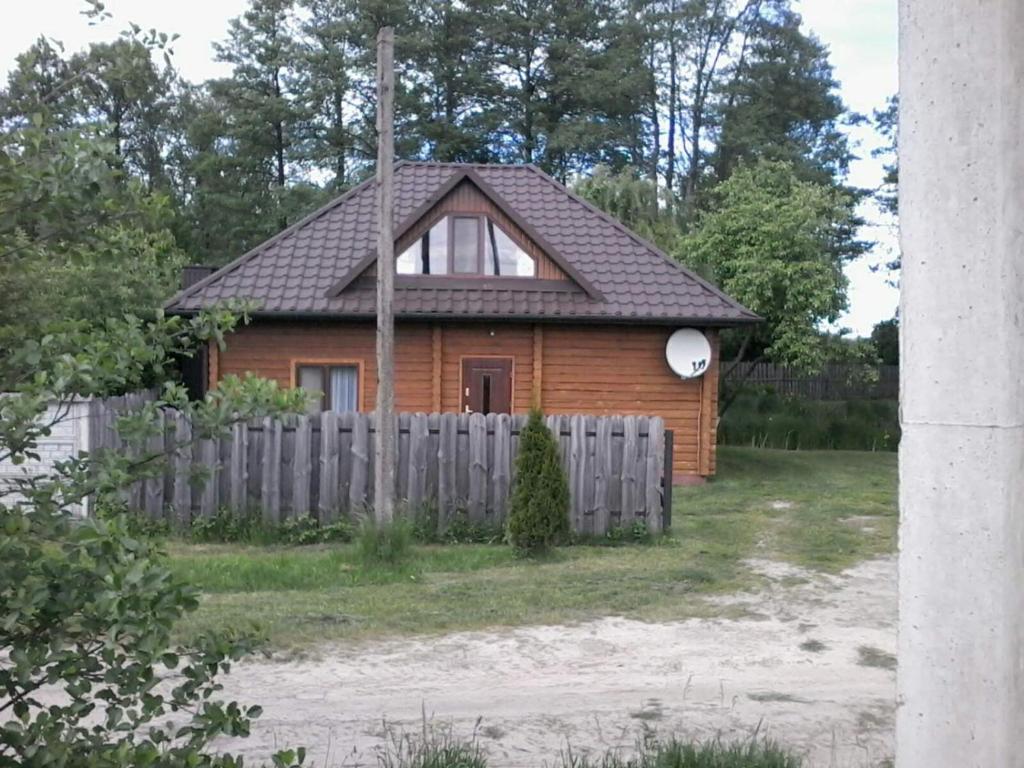 a wooden house with a fence in front of it at Екомотель in Vulʼka
