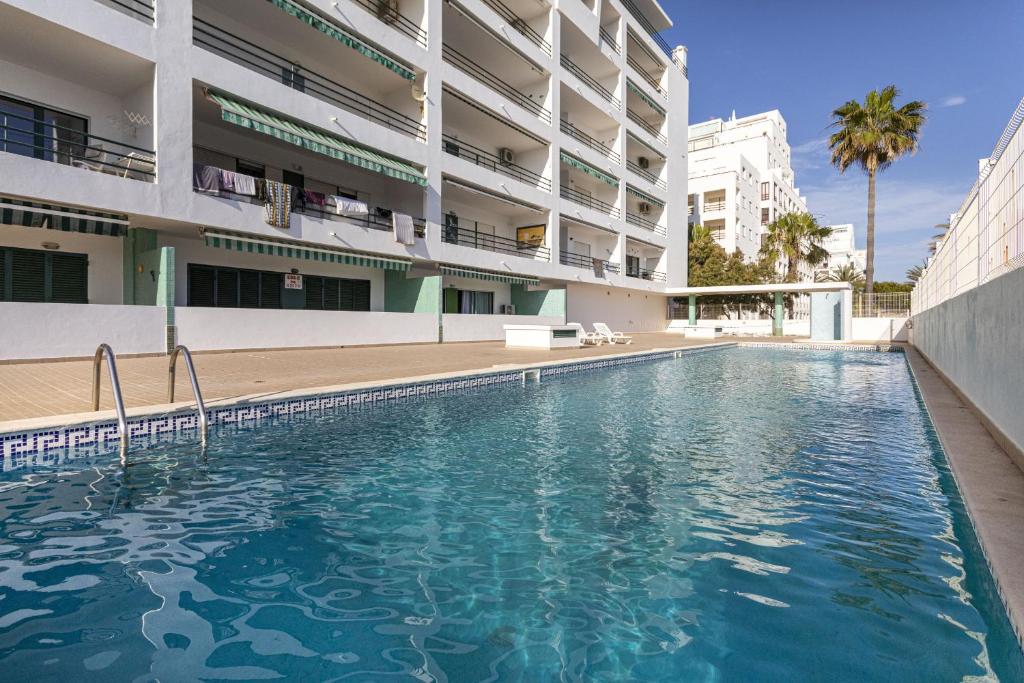 a swimming pool in front of a building at Miral 2 - Beach front apartment with pool in Quarteira