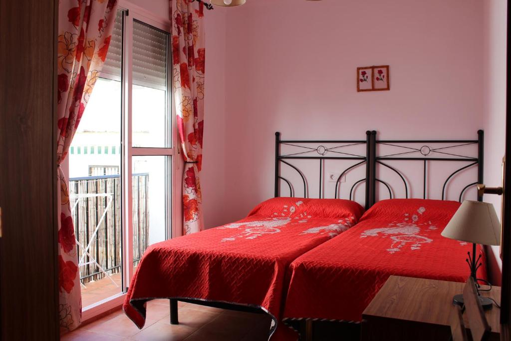 コニル・デ・ラ・フロンテーラにあるapto centrico Tirso de Molinaのベッドルーム1室(赤いシーツ付きのベッド1台、窓付)