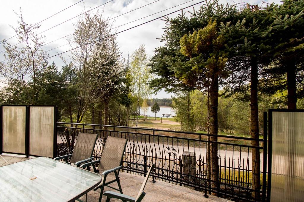 a balcony with a table and chairs and a fence at Dom z widokiem na jezioro Tajty - Wilkasy Zalesie in Giżycko