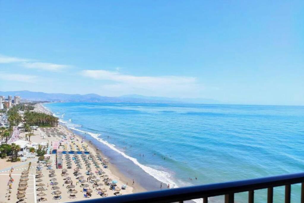 Blick auf einen Strand mit Sonnenschirmen und das Meer in der Unterkunft Amazing frontline sea views Studio apartment Castillo Del Vigia Torremolinos in Torremolinos