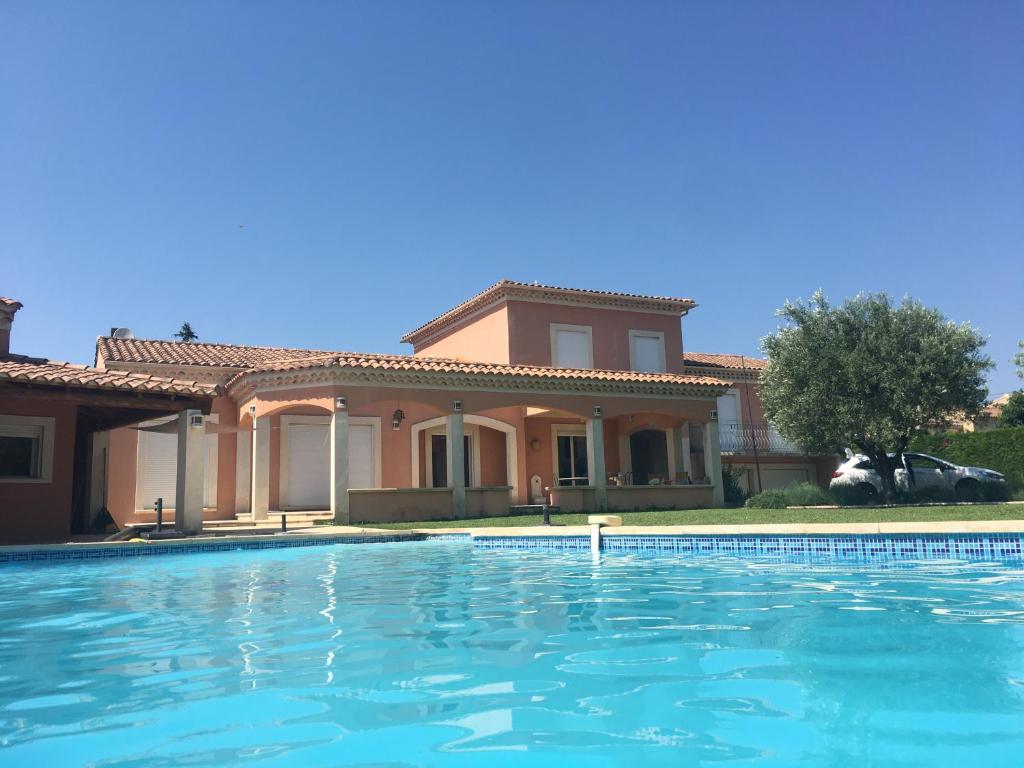 una casa con piscina frente a ella en Villa et maisonnette provençales en Carpentras