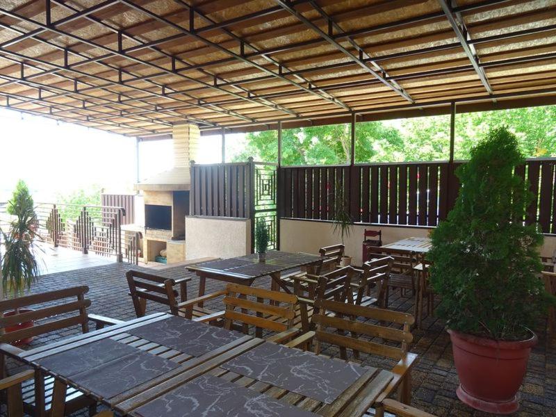 un patio al aire libre con mesas y sillas y una maceta en Guest House Milana, en Novomikhaylovskiy