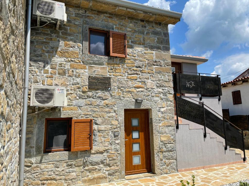ein Steingebäude mit braunen Türen und Fenstern in der Unterkunft Villa Sanela in Pobegi