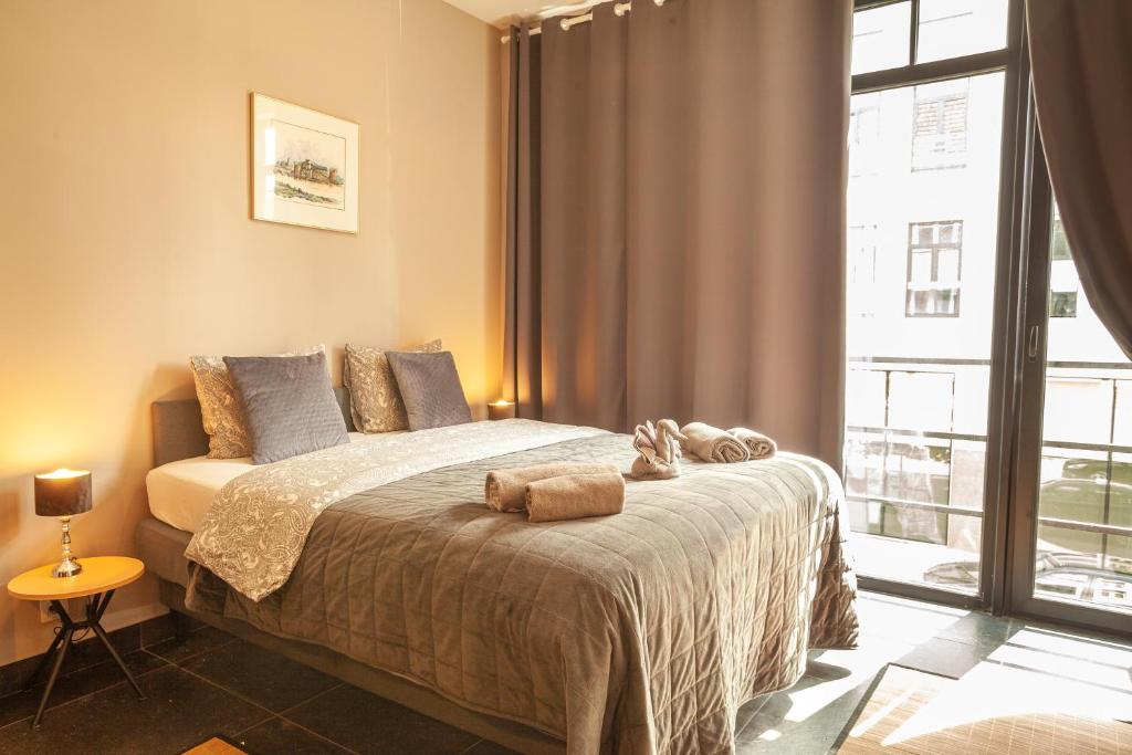 sypialnia z łóżkiem i dużym oknem w obiekcie Luxury Suites Central w Antwerpii