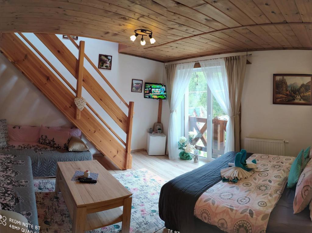 1 dormitorio con cama y techo de madera en Privat Gazda Pension, en Ždiar