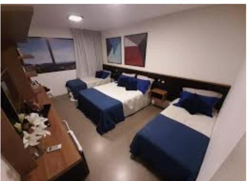 a hotel room with two beds and a desk at Solar Pedra da Ilha in Penha