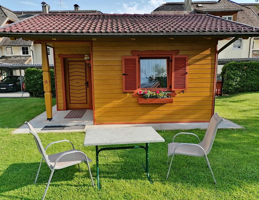 une petite maison avec une table et deux chaises dans l'établissement Ferienhaus Mentil, à Greifenburg