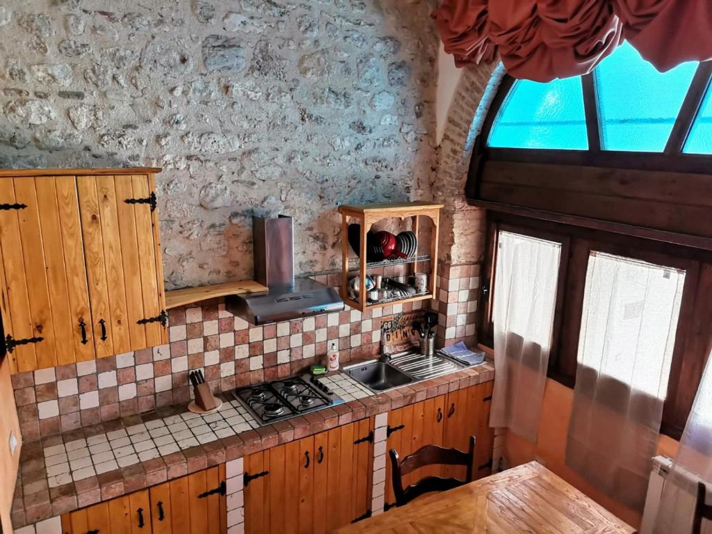 uma cozinha com um lavatório e uma bancada em Piazzetta Del Forno - Monolocale con Soppalco em Assergi