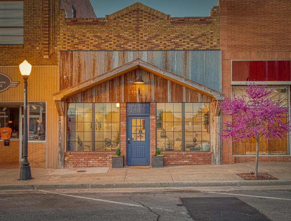 a building with a blue door on a street at Bluebird Inn Elk City in Elk City