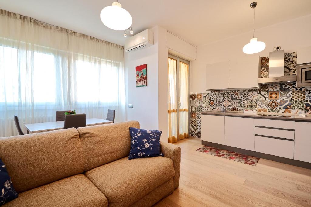 a living room with a couch and a kitchen at Skyline Apartment in Milan