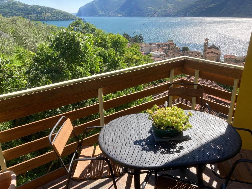 a table on a balcony with a view of the water at CasaGialla in Marone