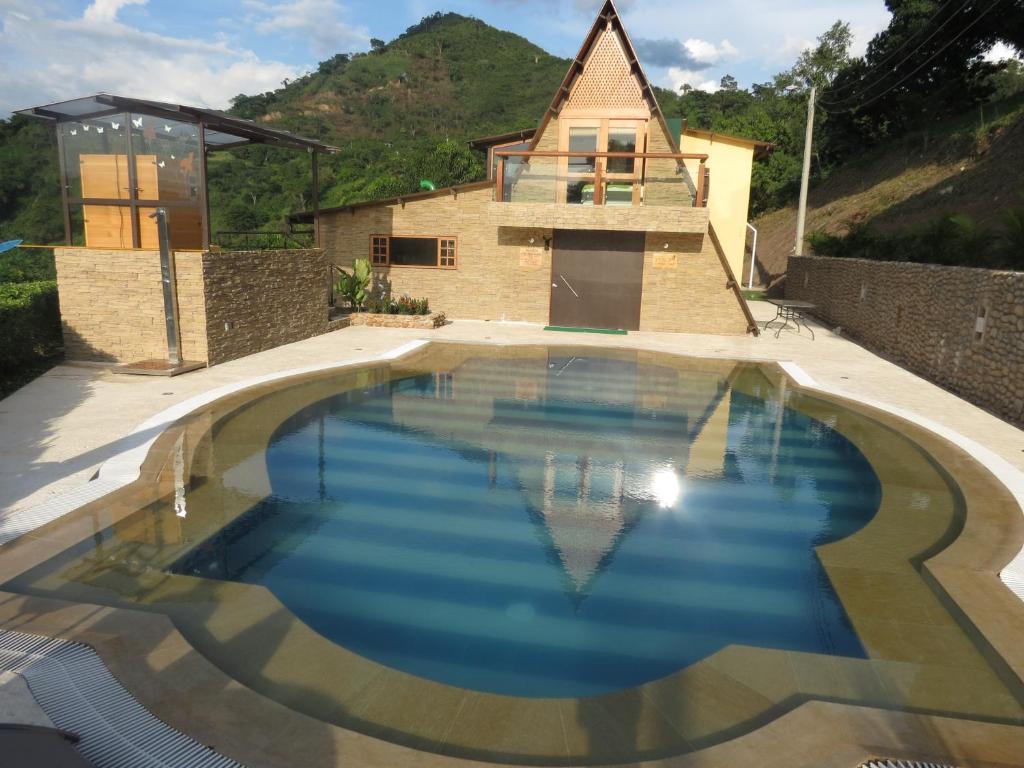 a swimming pool in front of a house at Areca Leisure Centre in Anapoima